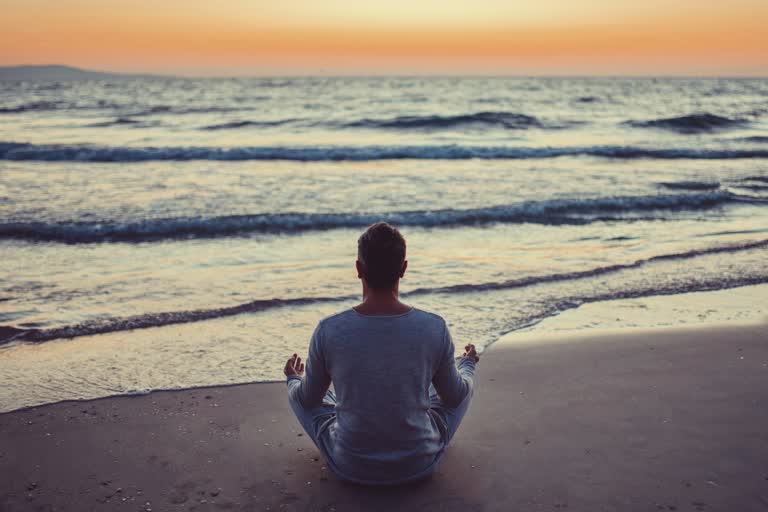 Person finding peace by the ocean